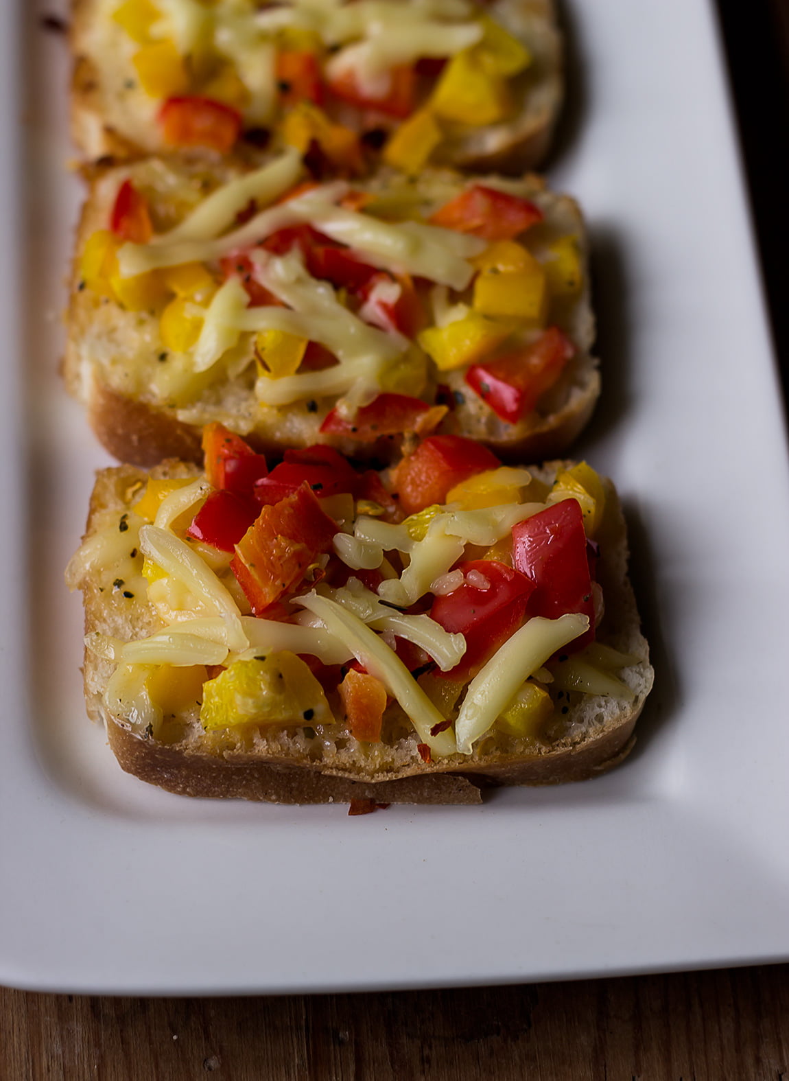 Overhead shot of Garlic Chilli Cheese Toast slices arranged neatly on a plate