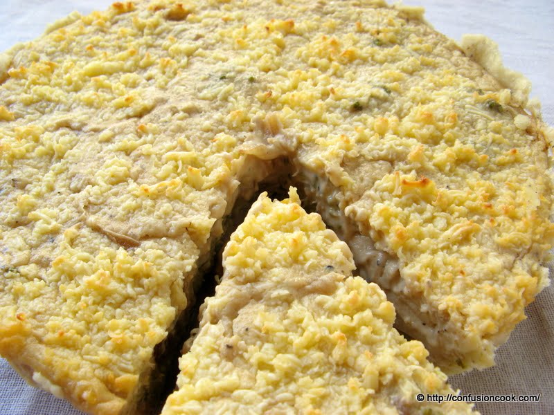 A slice of Eggless Caramelized Onion and Corn Quiche showcasing a golden, flaky crust and savory filling