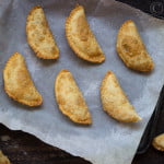 Freshly fried Karanji with crispy edges and a glossy finish, placed on a festive tray