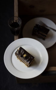 A slice of classic french opera cake served in a white plate