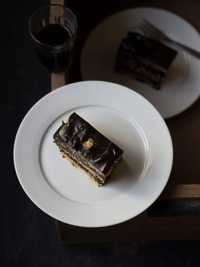 A slice of classic french opera cake served in a white plate