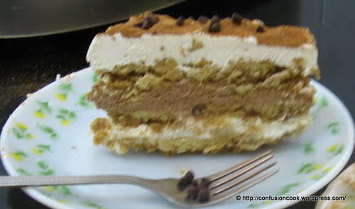 Close-up of a layered eggless tiramisu with a dusting of cocoa powder