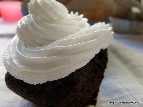 Freshly baked red velvet cupcakes with cream cheese frosting.