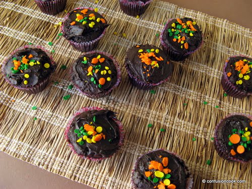 Chocolate cupcakes arranged on a white plate, topped with golden sprinkles