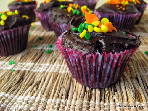 Close-up of a chocolate cupcake topped with colorful sprinkles