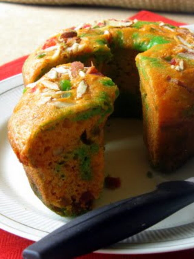 Freshly baked eggless tutti frutti cake loaf on a wooden board