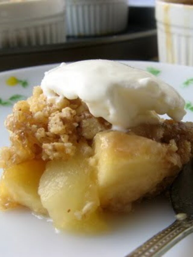 Close-up of a serving of apple and pear crumble with a scoop of vanilla ice cream