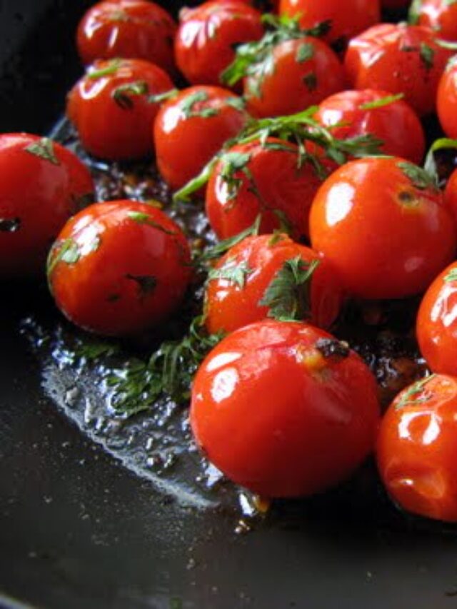 A close-up of herb-roasted cherry tomatoes on a baking sheet