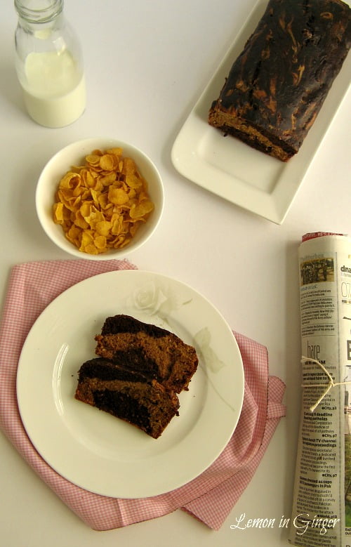 Freshly baked marbled banana bread loaf sliced on wooden board
