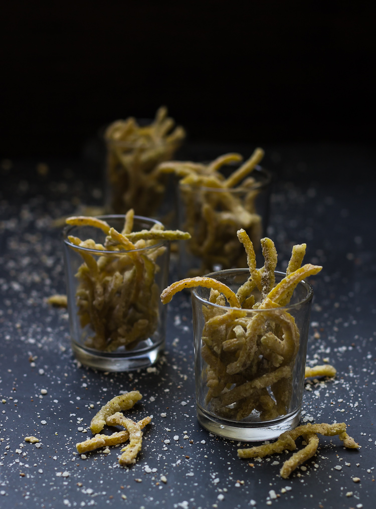 A glass container filled with vibrant candied citrus strips