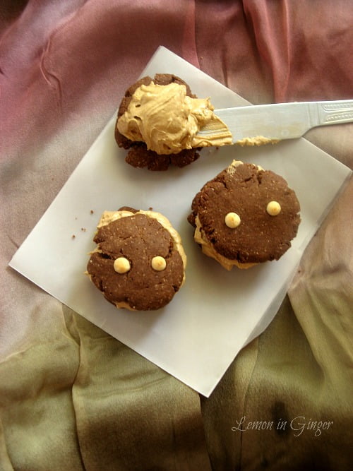Freshly baked cookies being piped with buttercream frosting