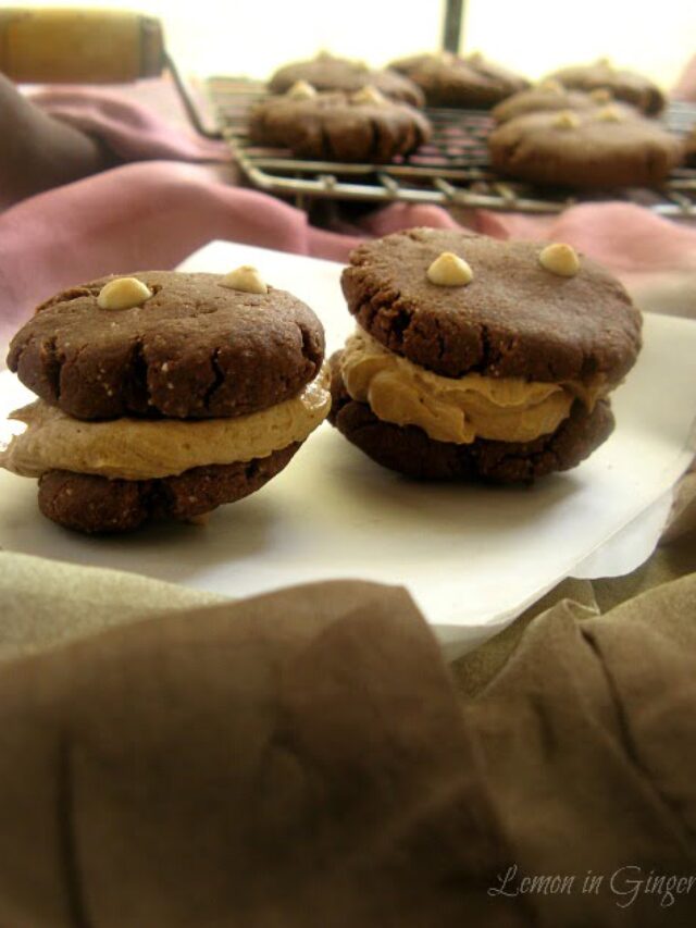 Freshly baked cookies being piped with buttercream frosting