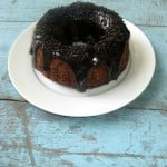 Close-up of a moist slice of triple chocolate cake with glossy ganache
