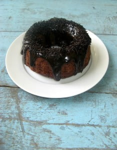 Close-up of a moist slice of triple chocolate cake with glossy ganache
