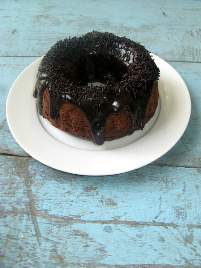 Close-up of a moist slice of triple chocolate cake with glossy ganache