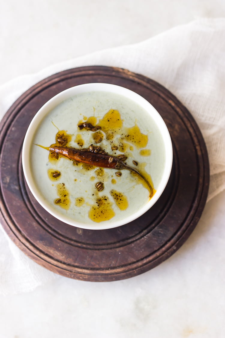 Bowl of creamy Bathua ka Raita garnished with roasted cumin and coriander
