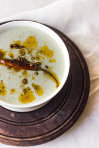 Bathua raita garnished with red chili powder and fresh coriander