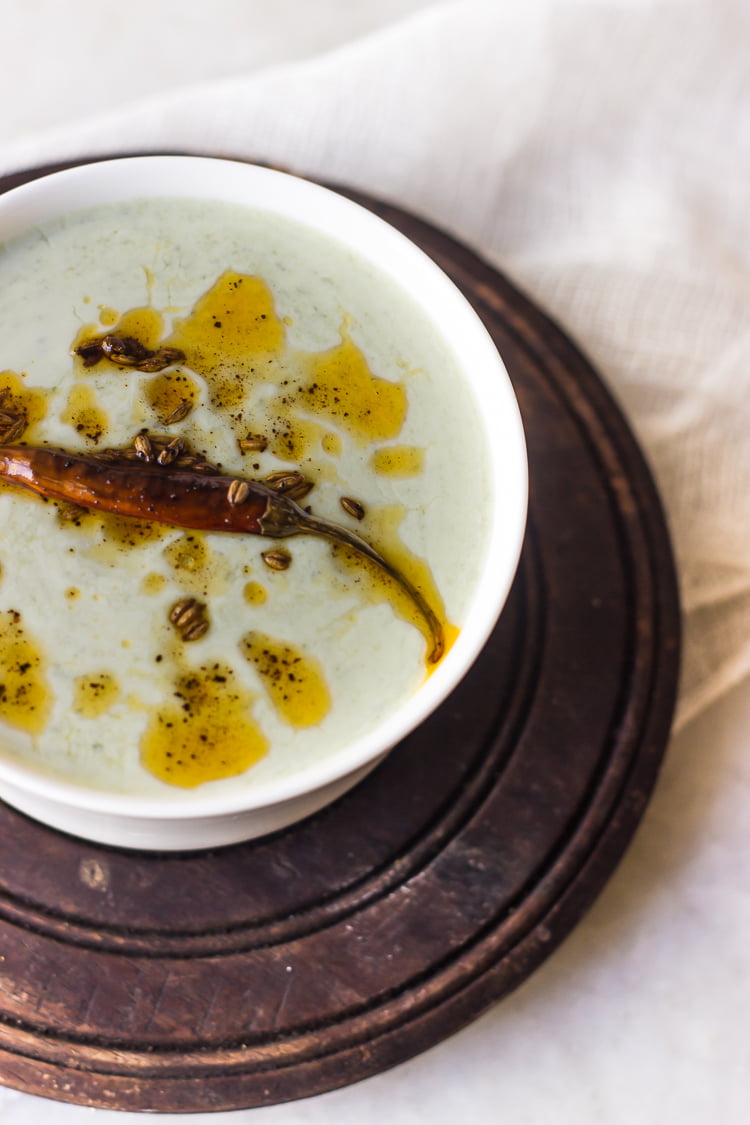 Bathua raita garnished with red chili powder and fresh coriander
