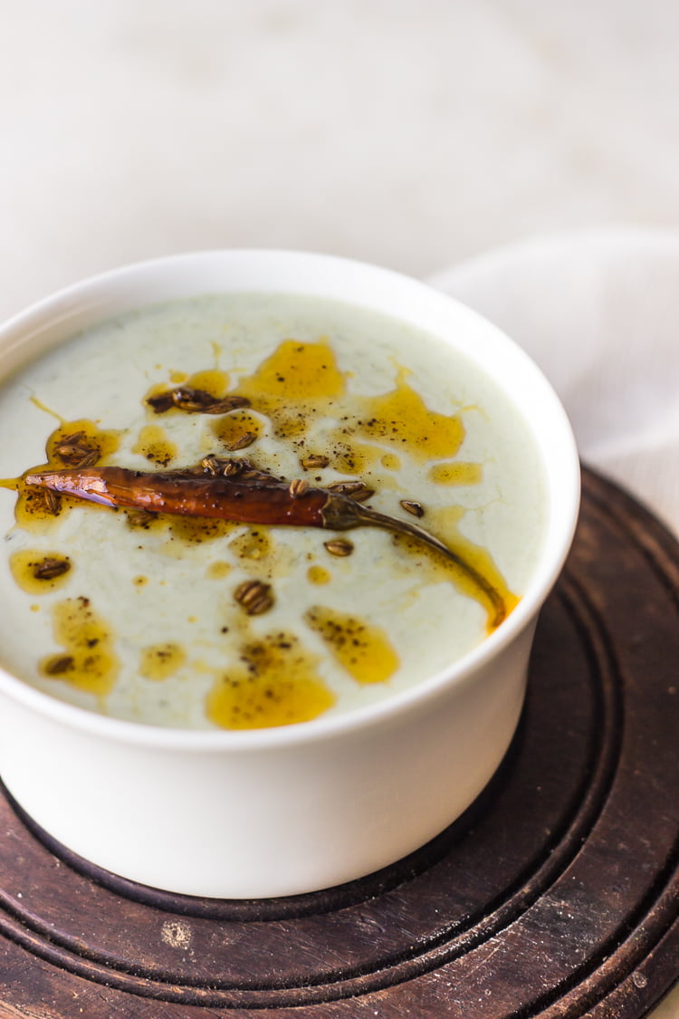 Top view of Bathua raita served in an earthen bowl with a spoon