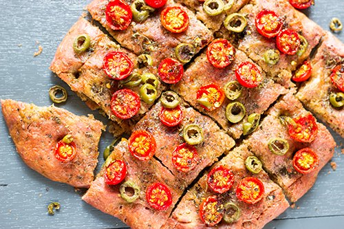 Close-up of beetroot focaccia with vibrant pink hue and herb topping