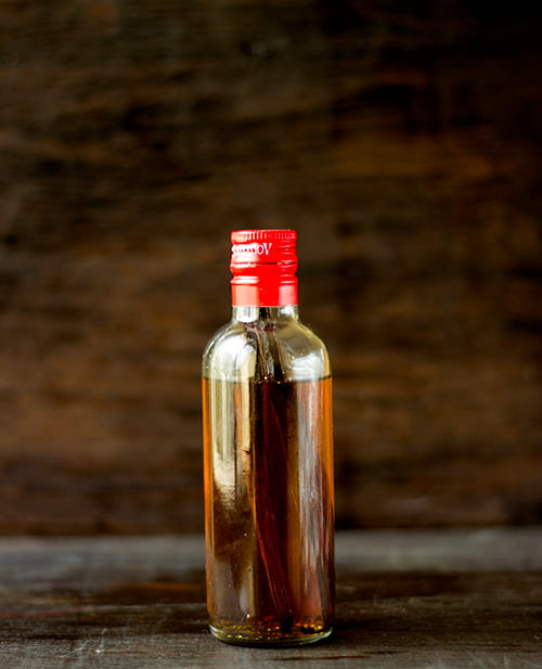 Small glass bottle of homemade vanilla extract with vanilla pods
