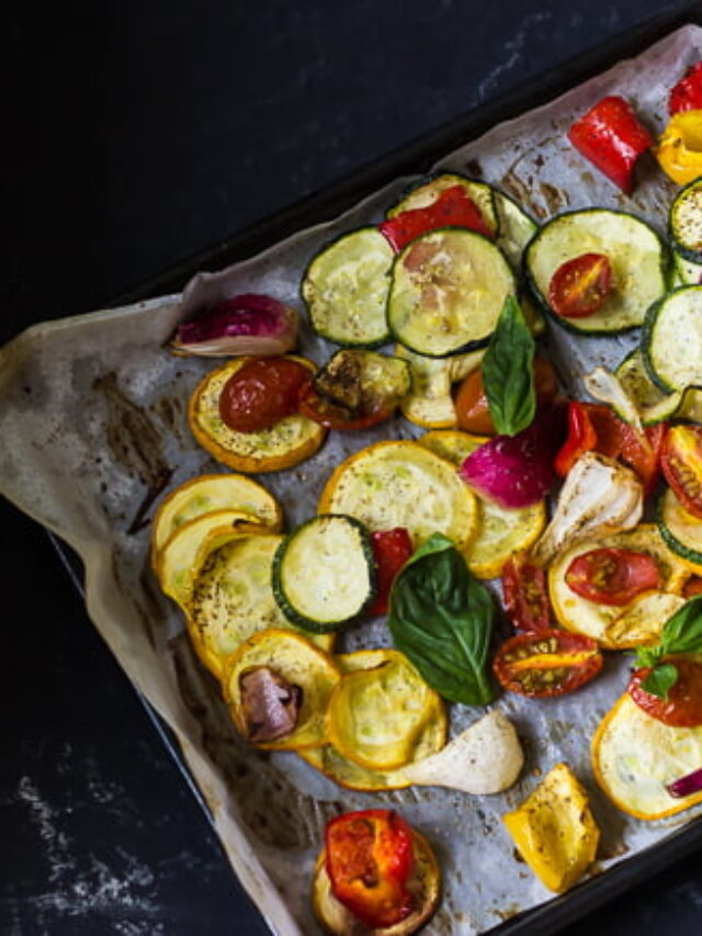 Roasted vegetables garnished with fresh herbs and seasoning on a tray