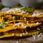 Moong dal chilla garnished with a sprinkle of cumin seeds and fresh coriander