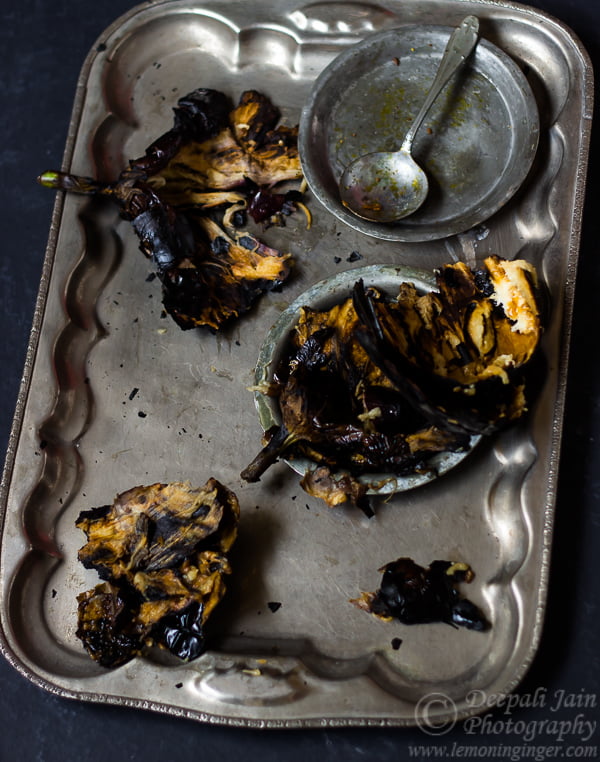 Roasted eggplant being mashed in a bowl for Baingan Bharta