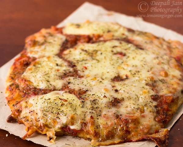 Close-up of a freshly baked whole wheat Margherita pizza topped with melted mozzarella and basil