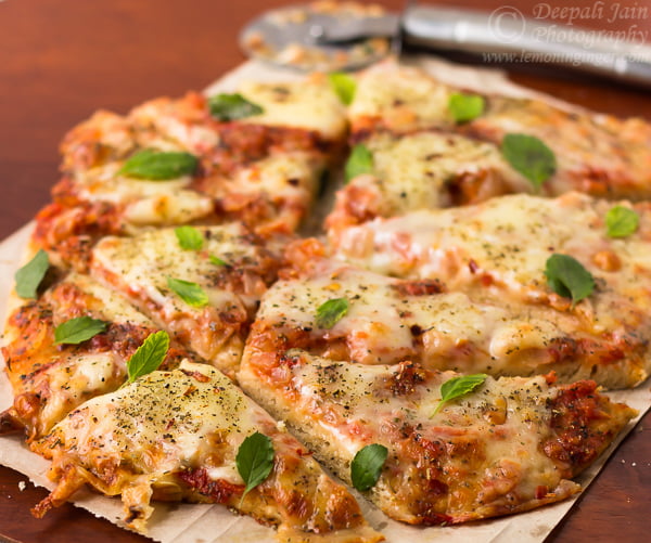 Sliced whole wheat Margherita pizza showing golden crust and melted cheese
