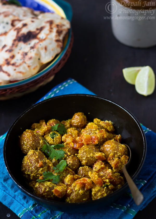 Close-up view of Bengali Aloo Dum in a skillet, showcasing the rich and tender potatoes