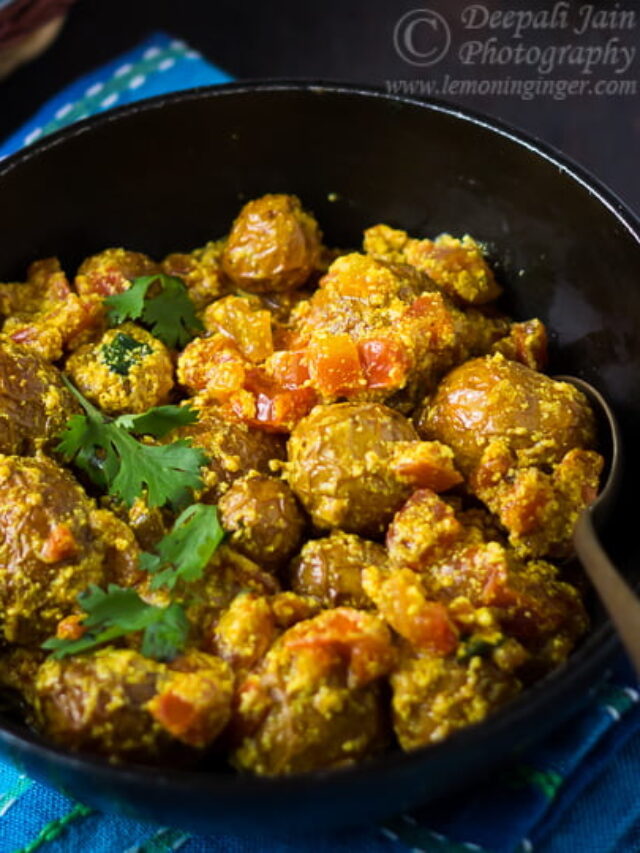 A delicious serving of Bengali Style Dry Dum Aloo (Bengali Aloo Dum) garnished with fresh coriander on a white plate