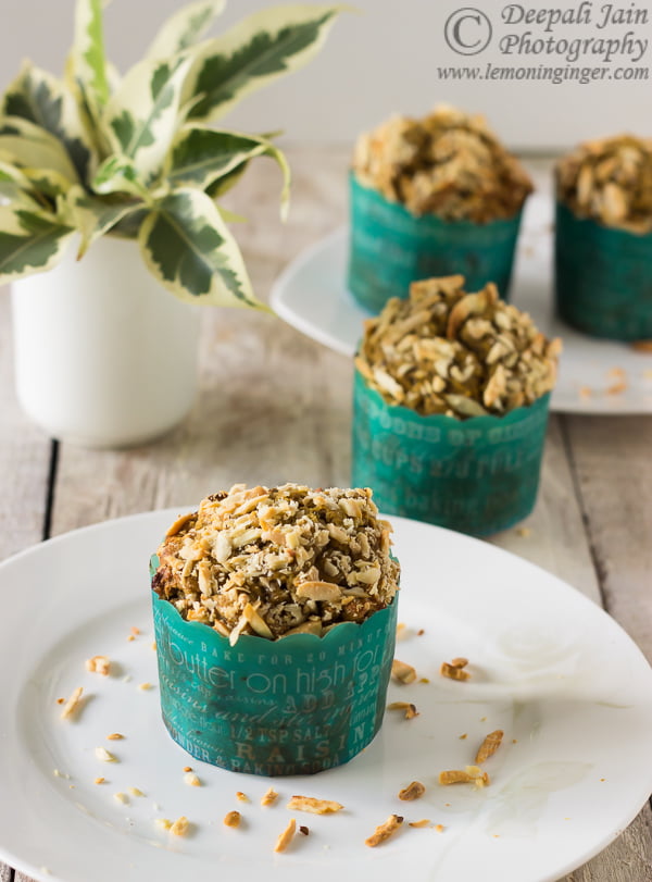 A close-up of freshly baked Eggless Date and Walnut Cupcakes topped with chopped walnuts