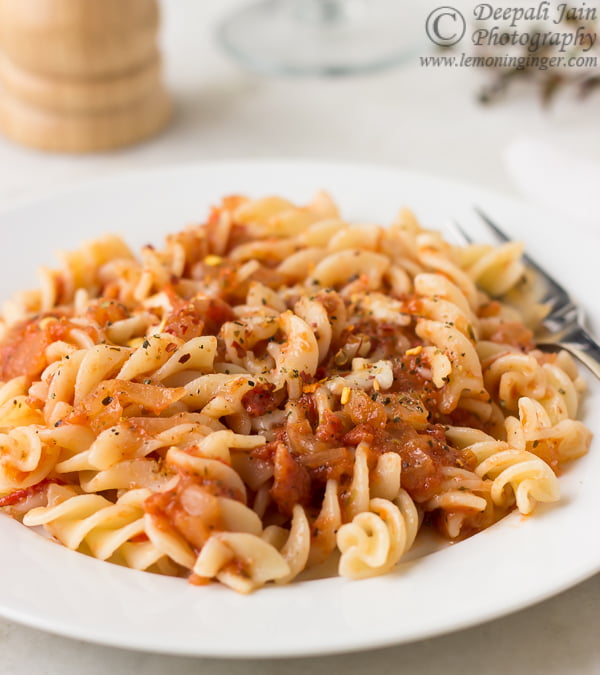 A serving of pasta in pizza sauce with a fork