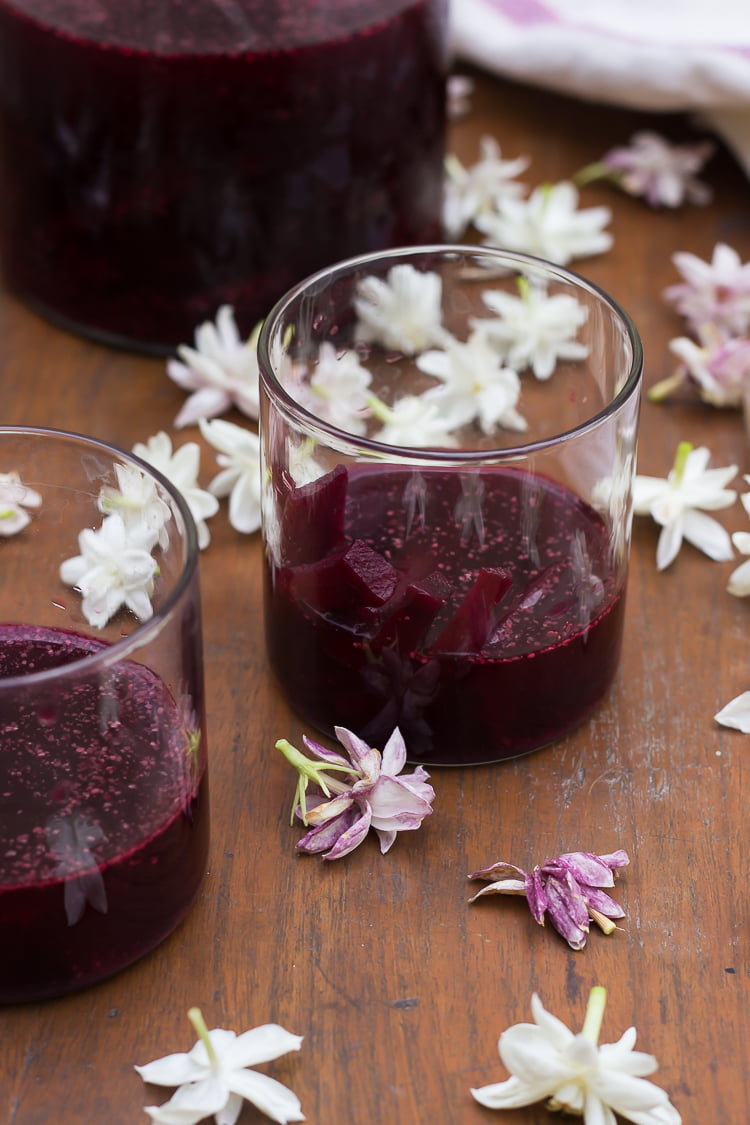 A rustic close-up of Kanji brewing in a glass jar, showcasing the vibrant purple hues of beetroot