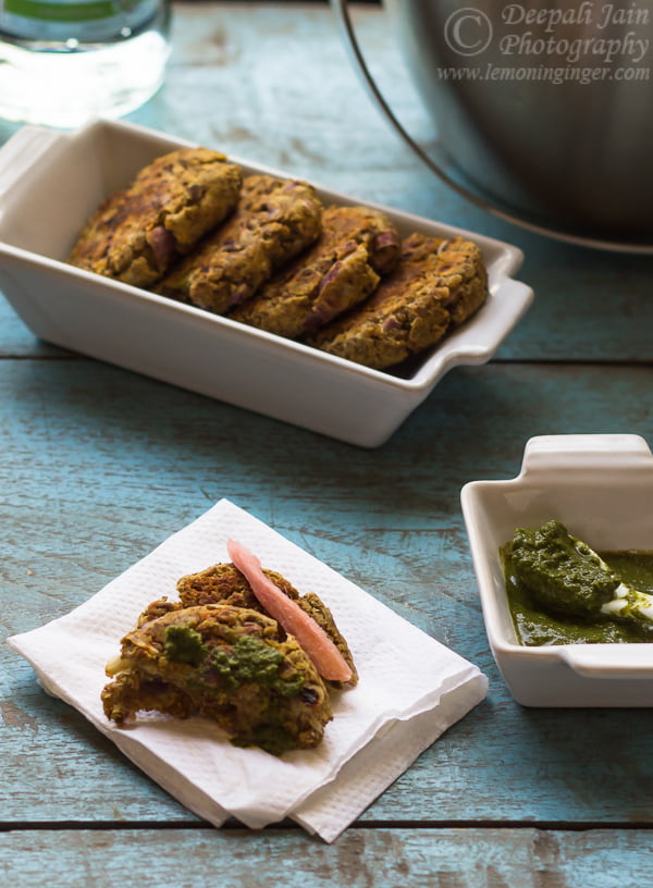Kebabs arranged on a platter with a small bowl of mint chutney