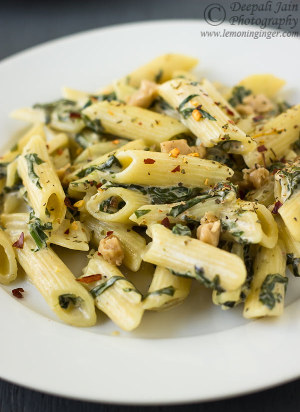Freshly cooked creamy spinach pasta with a garnish of chilli flakes