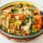 Close-up of vibrant Hyderabadi Veg Dum Biryani garnished with fried onions and coriander