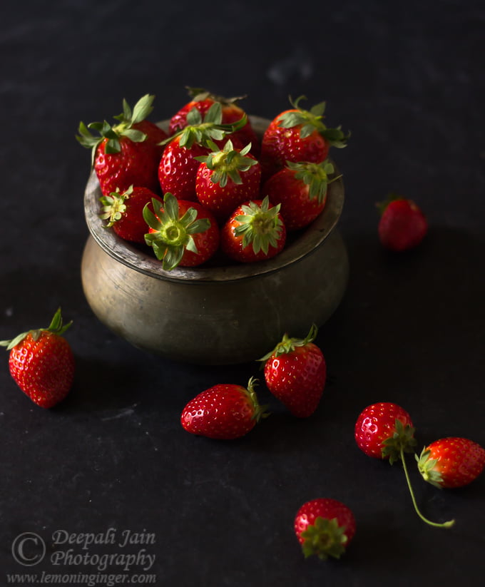 A bowl filled with juicy, fresh strawberries on a wooden table
