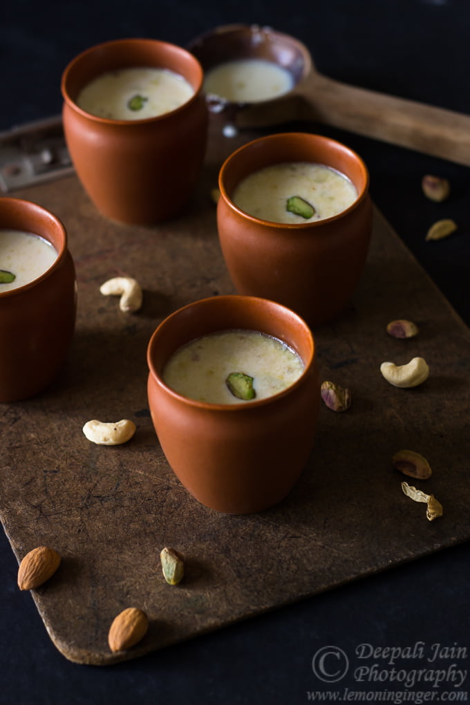 Masala Doodh (Masala Milk) topped with a sprinkle of spices and garnished with slivered almonds