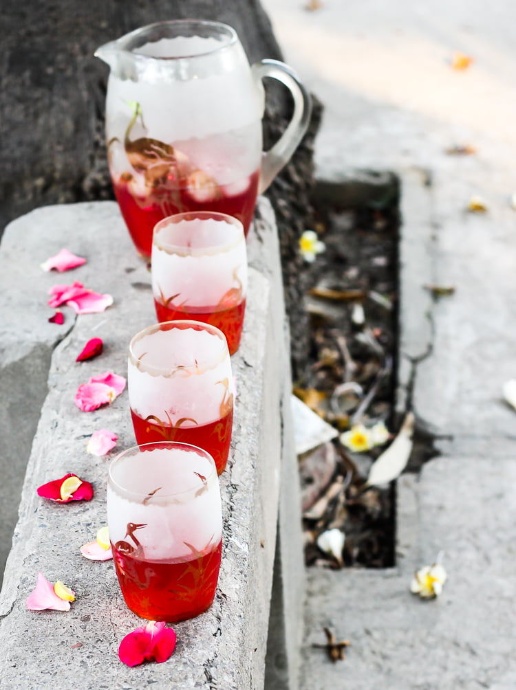 A vibrant pink Rooh Afza drink served in a mason jar with a straw and mint garnish