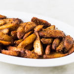 Crispy Arbi slices being coated with spice mix