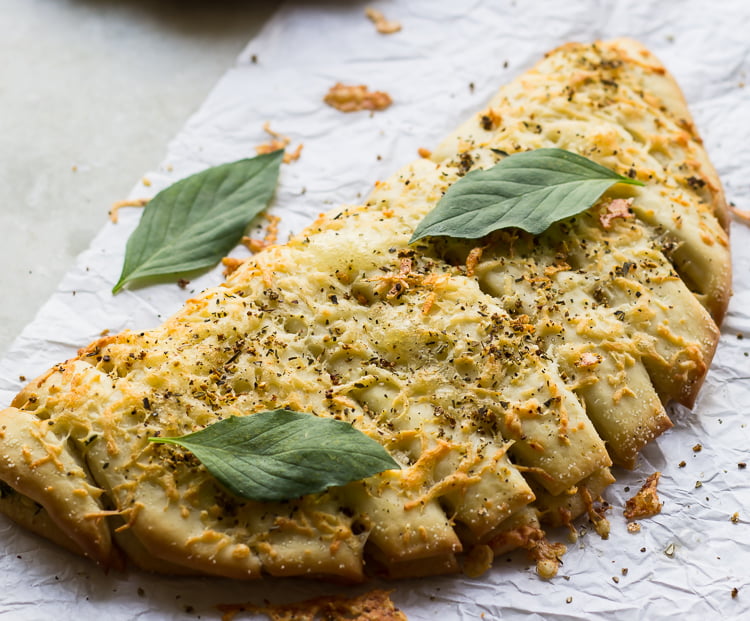 Golden brown cheesy garlic sticks served on a wooden platter