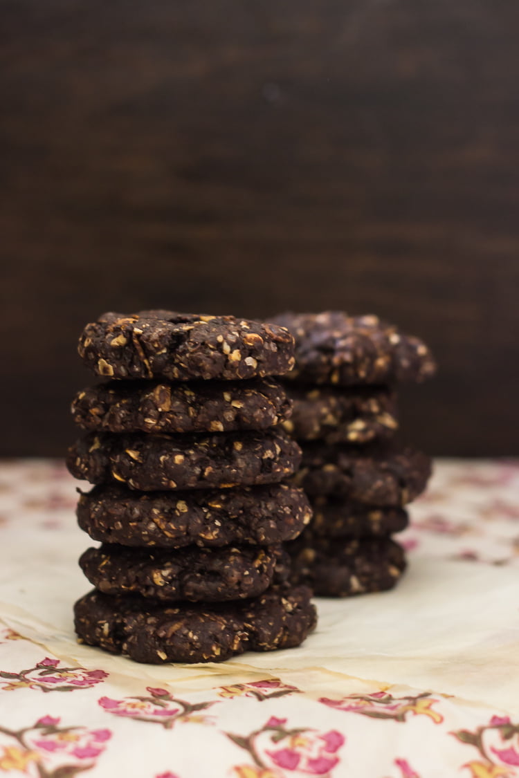 A close-up of chewy chocolate brownie oatmeal cookies with a cracked top