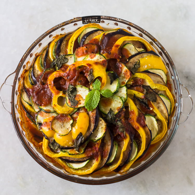 A vibrant dish of Baked Ratatouille with colorful layers of sliced vegetables