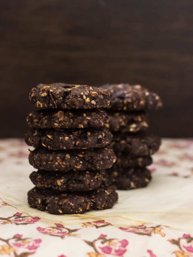 A close-up of chewy chocolate brownie oatmeal cookies with a cracked top