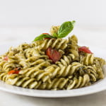 Final plated dish of Sicilian pesto pasta with basil garnish