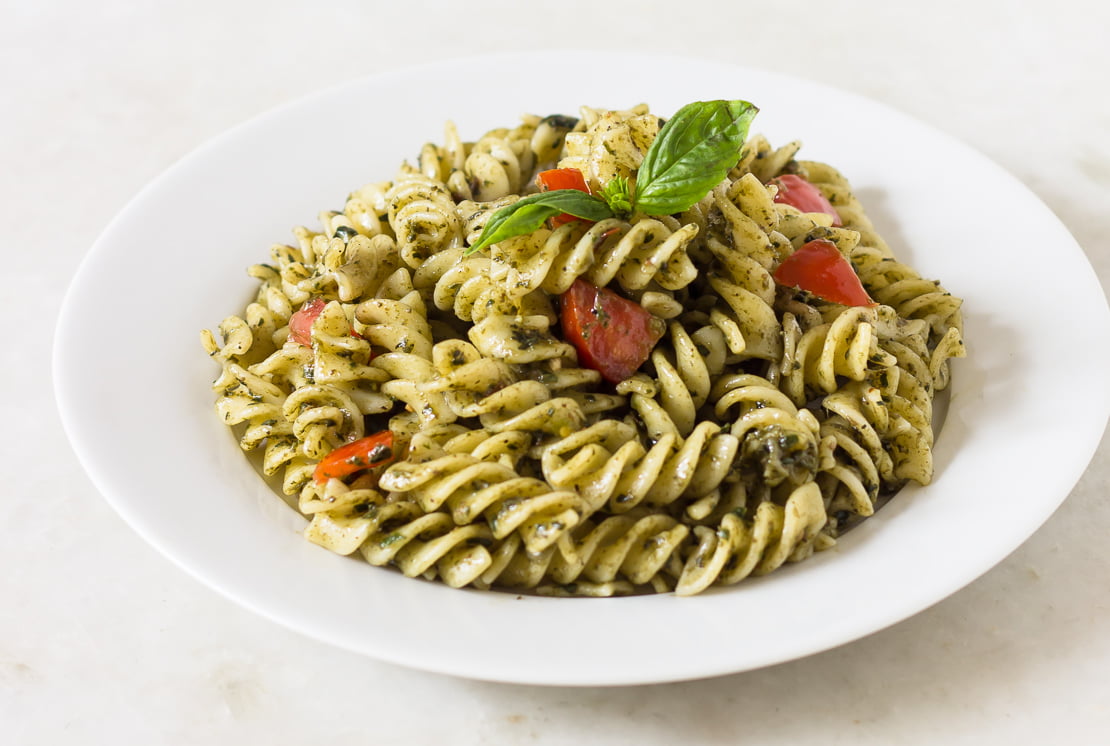 Final plated dish of Sicilian pesto pasta with basil garnish