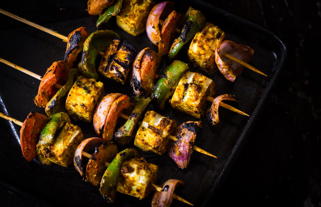 Restaurant-style Tandoori Paneer Tikka served on a platter with fresh mint chutney