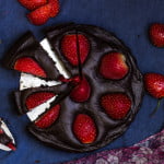 Close-up of a slice of no-bake chocolate strawberry tart with fresh strawberries on top